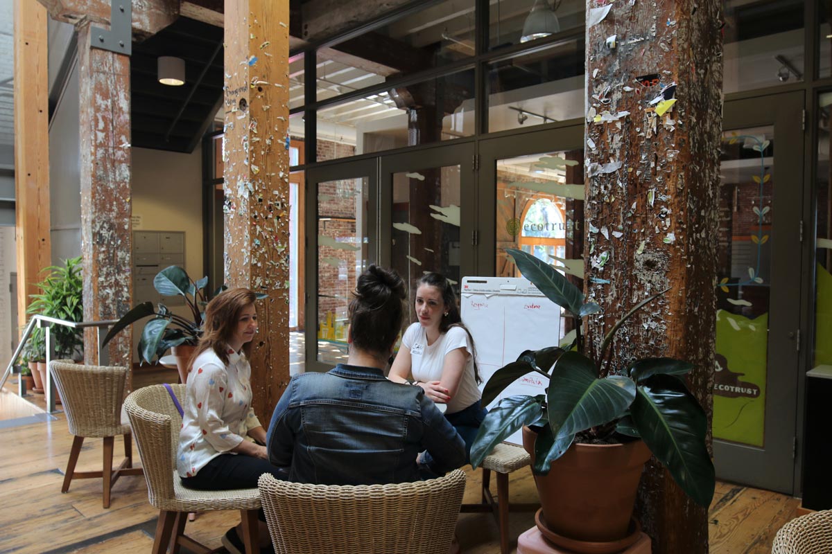 Three people sitting in a circle in an open office