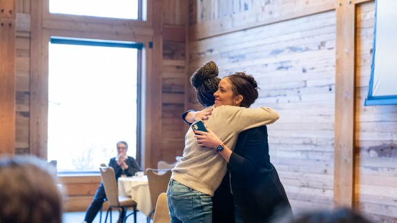 Two Summit participants hug each other